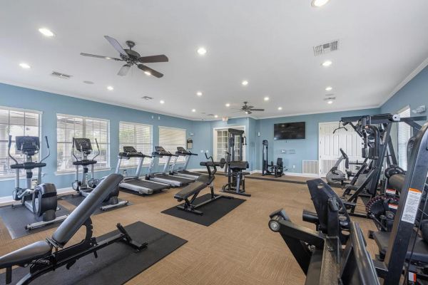 Integra Landing Spacious gym room with treadmills, exercise bikes, strength machines, and large windows letting in natural light.