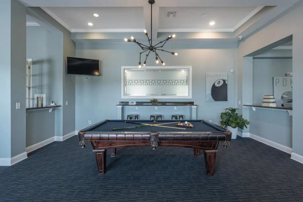 Integra Landing Modern game room with a pool table, cue sticks, wall art, a TV, and a contemporary chandelier.